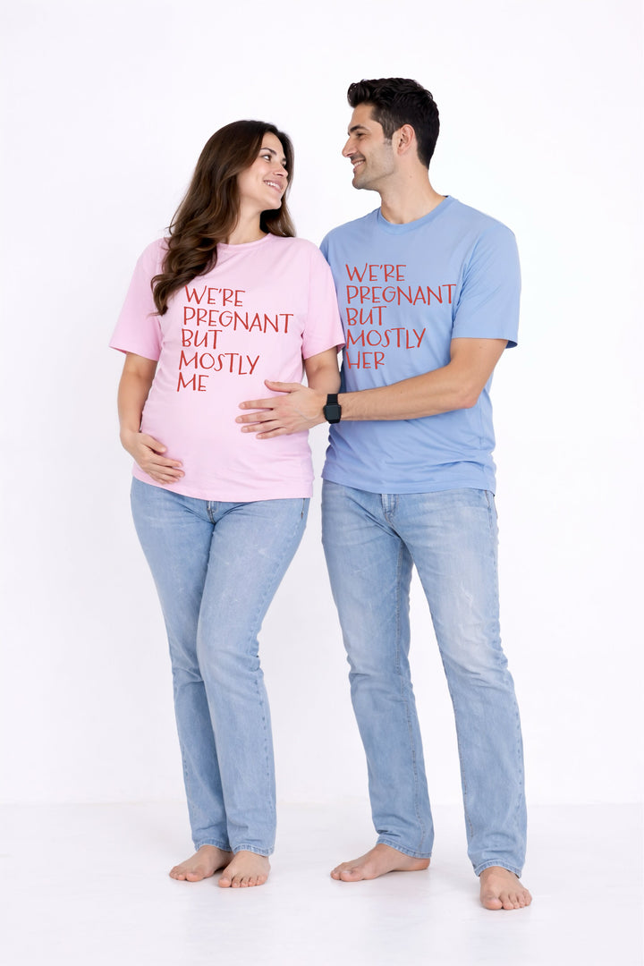 Pregnant woman and partner wearing matching t-shirts with humorous text on a white background